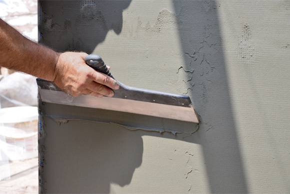 Remodeling Contractor in Boynton Beach, Lake Worth, Boca Raton, Delray Beach smoothing stucco on a wall