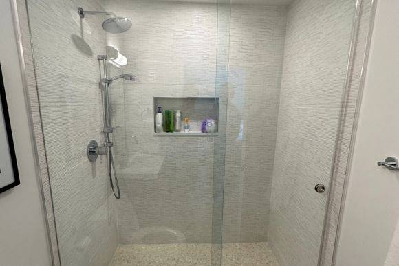 Bathroom remodel in Delray Beach with a glass door